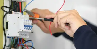Electrician installing and adjusting circuit breakers in an electrical panel in Arlington, TX