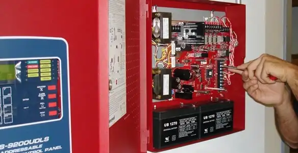 fire alarm installation service showing technician configuring fire alarm control panel in Arlington, TX