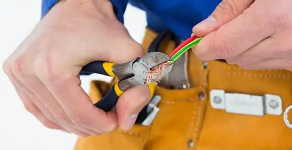 licensed electrician securing electrical wiring with professional tools during service work in Arlington, TX