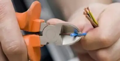 licensed electrician performing precise wire cutting and preparation during electrical service in Arlington, TX