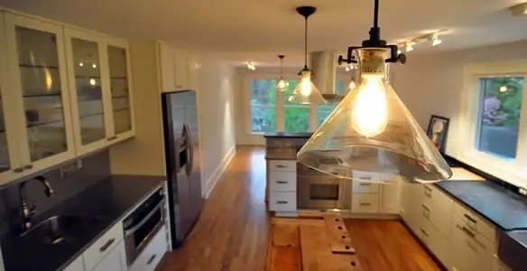 Residential electrician installing modern indoor light fixture in a home in Arlington, TX