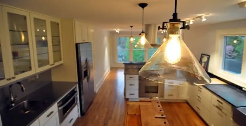 Residential electrician installing modern indoor light fixture in a home in Arlington, TX